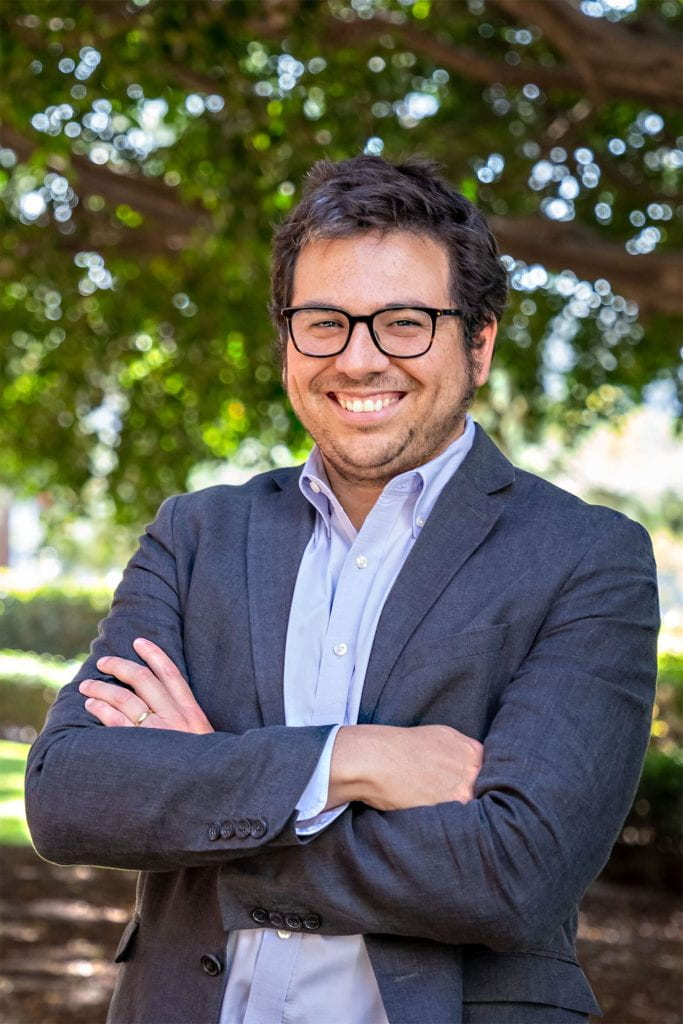 Outdoor photo of Félipe Jimenez, Associate Professor of Law and Philosophy at USC Gould School of Law, smiling and arms crossed.